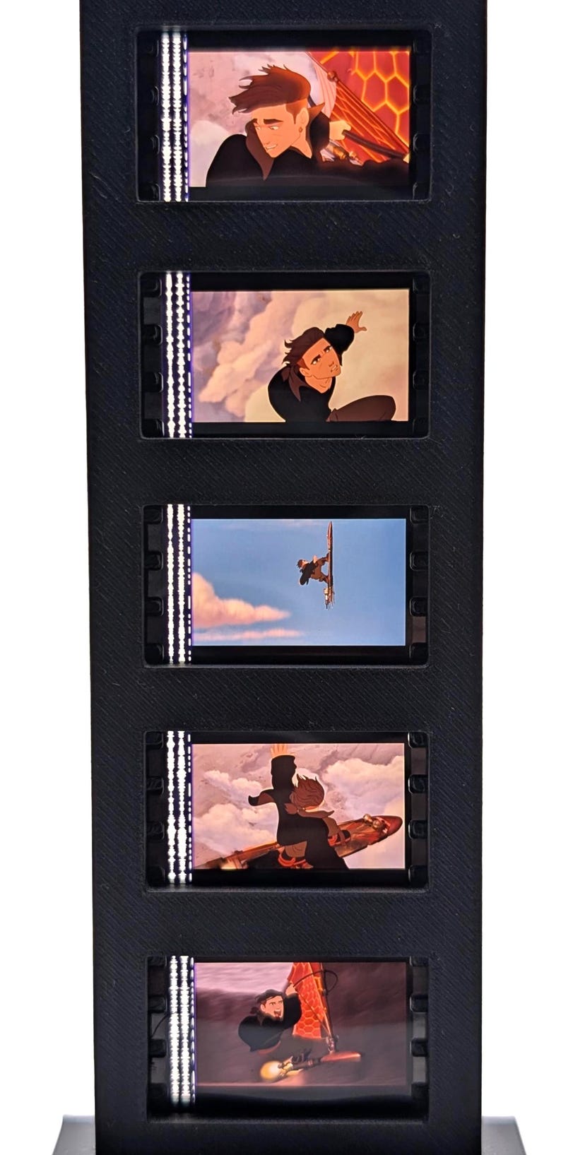 May include: A black, vertical display featuring five animated film cells. Each cell shows a scene with a character in various action poses. The scenes are lit with a white light on the left side of each cell.