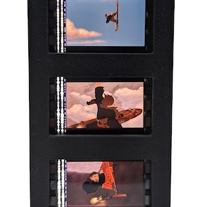 May include: A black, three-tiered display featuring three illuminated panels with animated scenes of a person windsurfing. The panels are framed in black and have vertical LED lights on the sides.