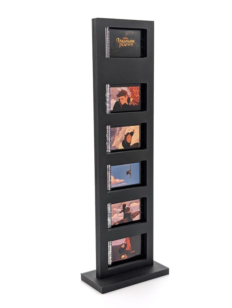 May include: A black display stand featuring six small, rectangular frames. Each frame contains a scene from the animated film "Treasure Planet." The top frame displays the film's title. The stand is made of a textured, dark material.