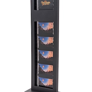 May include: A black display stand featuring the text "Treasure Planet" at the top. The stand holds multiple film strips with images of a ship sailing through a canyon. The stand is rectangular with a base.