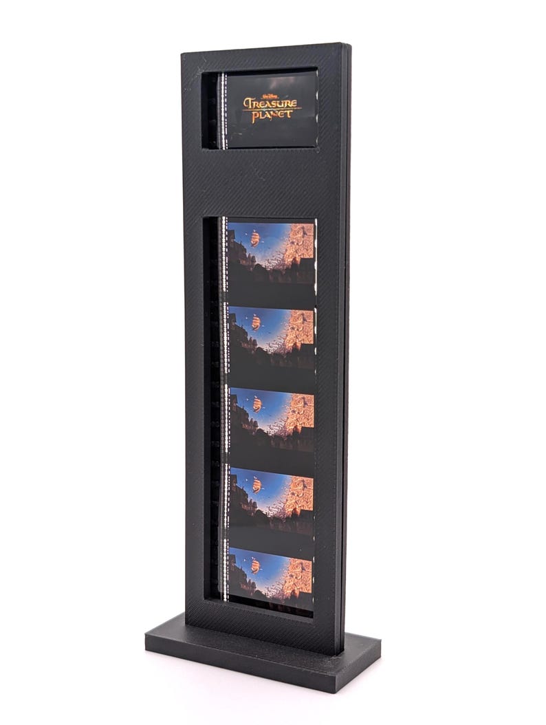 May include: A black display stand featuring the text "Treasure Planet" at the top. The stand holds multiple film strips with images of a ship sailing through a canyon. The stand is rectangular with a base.