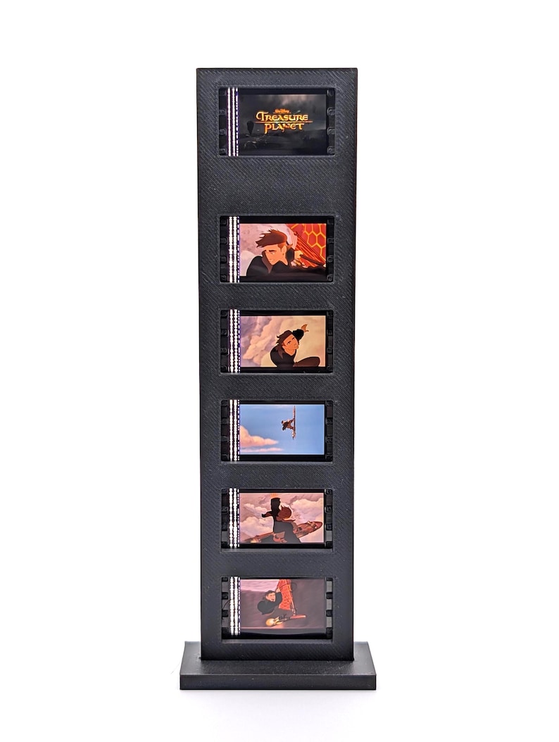 May include: A black display stand featuring six film cells from the animated movie "Treasure Planet." Each cell displays a different scene from the movie. The stand is rectangular with a square base and a textured surface.