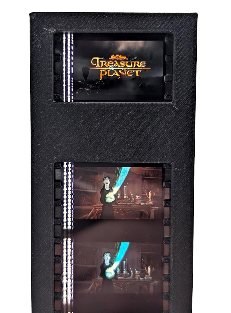 Puede incluir: Marco rectangular negro con el logotipo de Disney Treasure Planet e im&aacute;genes de tiras de pel&iacute;cula. La tira de pel&iacute;cula muestra escenas de la pel&iacute;cula, incluido un personaje que sostiene un objeto azul brillante.