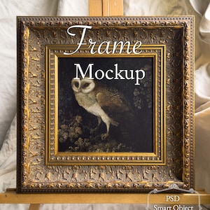 May include: A framed artwork mockup featuring an owl painting. The ornate, gold-toned frame surrounds a dark canvas with the text "Frame Mockup". The image is displayed on a wooden easel, with art supplies visible below.