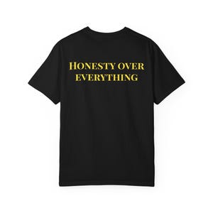 Könnte beinhalten: Schwarzes T-Shirt mit dem gelben Schriftzug "HONESTY OVER EVERYTHING". Der Text ist mittig auf der Rückseite des Shirts platziert. Ein schlichtes, lässiges Kleidungsstück.