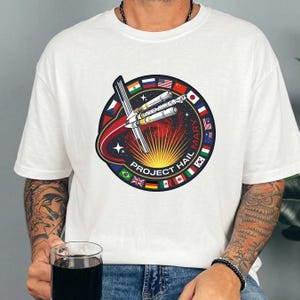 Pu&ograve; includere: Una tazza di ceramica bianca con manico nero e la scritta "But First, Coffee" in grassetto nero. La tazza &egrave; posta su uno sfondo sfocato, che suggerisce un'atmosfera accogliente.