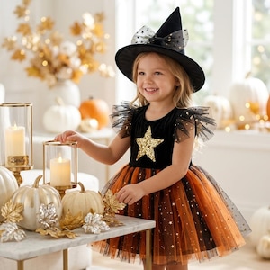 May include: A black witch hat with a sheer star-patterned bow and a dress featuring a black bodice with a gold sequined star, ruffled tulle sleeves, and a layered orange and black tulle skirt adorned with small gold star accents throughout.