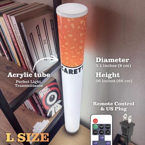 May include: A novelty lamp shaped like a cigarette, with a white base and an orange and brown filter. The lamp is 26 inches (66 cm) tall and 3.1 inches (8 cm) in diameter. It includes a remote control and a US plug.