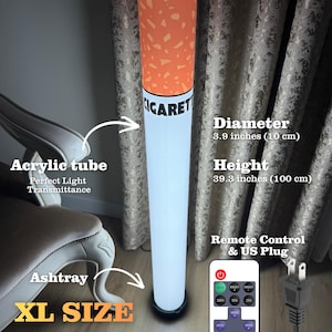 May include: A novelty floor lamp shaped like a cigarette, featuring an acrylic tube with perfect light transmittance. The lamp has a diameter of 3.9 inches and a height of 39.3 inches. Includes a remote control and US plug. The text "CIGARET" is visible.