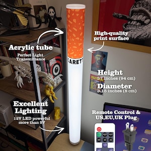May include: A cylindrical floor lamp shaped like a cigarette with an orange filter section and a white body. The lamp stands 94 cm tall with an 8 cm diameter. It features an acrylic tube, 12V LED lighting, a remote control, and a UK plug.