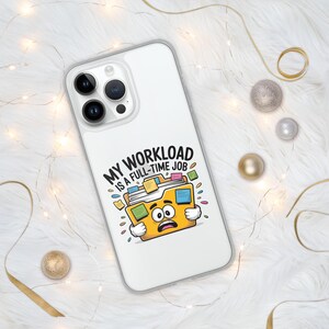 May include: A clear phone case with a cartoon image of a yellow file folder with a worried expression. The text "MY WORKLOAD IS A FULL-TIME JOB" is above the folder. The case is on a white fluffy surface with gold and silver decorative elements.