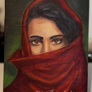 Puede incluir: Una pintura al óleo sobre lienzo que representa a una persona con cabello oscuro y ojos color ámbar, parcialmente cubierta por un pañuelo rojo intenso. La obra presenta un fondo verde oscuro e incluye una firma y el año 2026 en el borde.