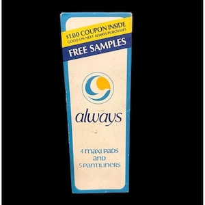 May include: A rectangular Always brand product box with a white center, blue borders, and a yellow top banner. The text reads $1.00 COUPON INSIDE, FREE SAMPLES, always, and 4 MAXI PADS AND 5 PANTILINERS. A circular blue and yellow logo is centered.