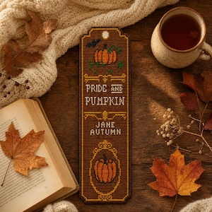 May include: A rectangular cross-stitch bookmark featuring a brown background with an orange pumpkin, a small black bat, and the text "PRIDE AND PUMPKIN" followed by "JANE AUTUMN" in white lettering, finished with a decorative oval frame around a pumpkin.
