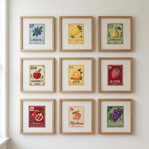 May include: Nine framed cross-stitch artworks featuring fruit and inspirational words. The artworks include a blueberry with "Peace", a lemon with "Self Control", and a pear with "Gentleness". Other artworks include an apple with "Goodness", an orange with "Joy", and a strawberry with "Love".