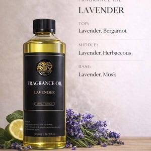 May include: A bottle of lavender fragrance oil with a black label, featuring the text "FRAGRANCE OIL LAVENDER". The bottle is next to a sprig of lavender and a lemon slice. The bottle contains 16.9 fl oz.