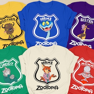 May include: A selection of Zootopia-themed t-shirts in various colours. Each shirt displays a different character illustration within a shield, with text such as "Brother", "Sister", "Daddy", and "Mommy". The shirts are in colours like yellow, blue, green, white, purple, and red.