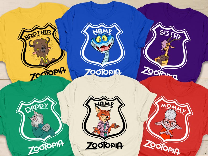 May include: A selection of Zootopia-themed t-shirts in various colours. Each shirt displays a different character illustration within a shield, with text such as "Brother", "Sister", "Daddy", and "Mommy". The shirts are in colours like yellow, blue, green, white, purple, and red.