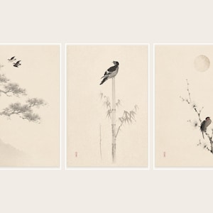 Puede incluir: Un tríptico de grabados artísticos de inspiración asiática. Cada grabado presenta un ave en un entorno natural, representado en tonos grises y negros sobre un fondo crema. Uno muestra aves en vuelo, otro un ave posada en bambú y el último un ave en una rama florecida.