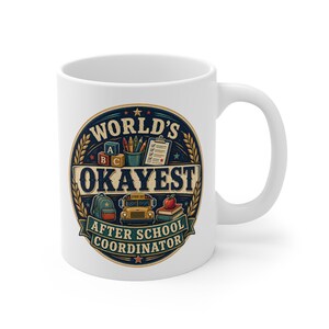 May include: A white ceramic mug featuring a circular graphic with the text "WORLD'S OKAYEST AFTER SCHOOL COORDINATOR." The design includes illustrations of alphabet blocks, a pencil cup, a clipboard, a backpack, a school bus, and books.