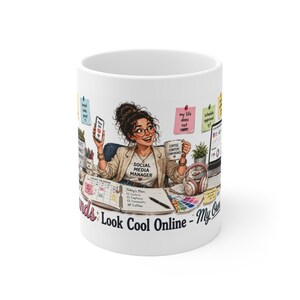 May include: A white ceramic mug featuring a colorful illustration of a social media manager at a desk. The design includes a person with glasses, a phone, a coffee mug labeled 'COFFEE CONTENT CONFIDENCE', a calendar, sticky notes, and the text 'SOCIAL MEDIA MANAGER' on a t-shirt, with the phrase 'Look Cool Online' printed at the bottom.