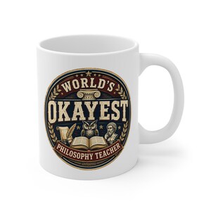 Könnte beinhalten: Ein weißer Keramikbecher mit einem kreisförmigen Motiv und dem Text "WORLD'S OKAYEST PHILOSOPHY TEACHER". Das Design zeigt eine klassische Säule, eine Eule, ein offenes Buch, eine Feder und eine Philosophenbüste in Marineblau, Rot und Gold.