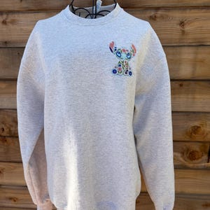 May include: A set of three ceramic mugs with a speckled, matte finish. The mugs are in shades of cream, light gray, and dark gray. Each mug has a simple, minimalist design, perfect for coffee or tea.