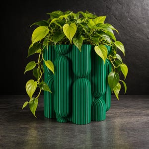 Peut inclure: Un pot de fleurs vert vif doté d'un extérieur texturé avec des colonnes verticales, arrondies et nervurées de hauteurs variables. Une plante philodendron luxuriante aux feuilles en forme de cœur vert lime et émeraude en sort.