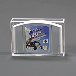 May include: A gray Nintendo 64 video game cartridge for the game "1080° Snowboarding" is encased in a clear acrylic display case. The game cartridge features a blue and white label with a snowboarder graphic and the Nintendo logo.