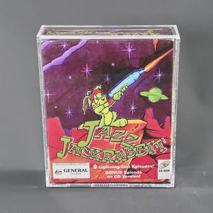 May include: A clear plastic case containing a CD-ROM for the video game "Jazz Jackrabbit." The cover art features a green rabbit holding a futuristic weapon against a purple space background with the game's title in large, colorful letters.