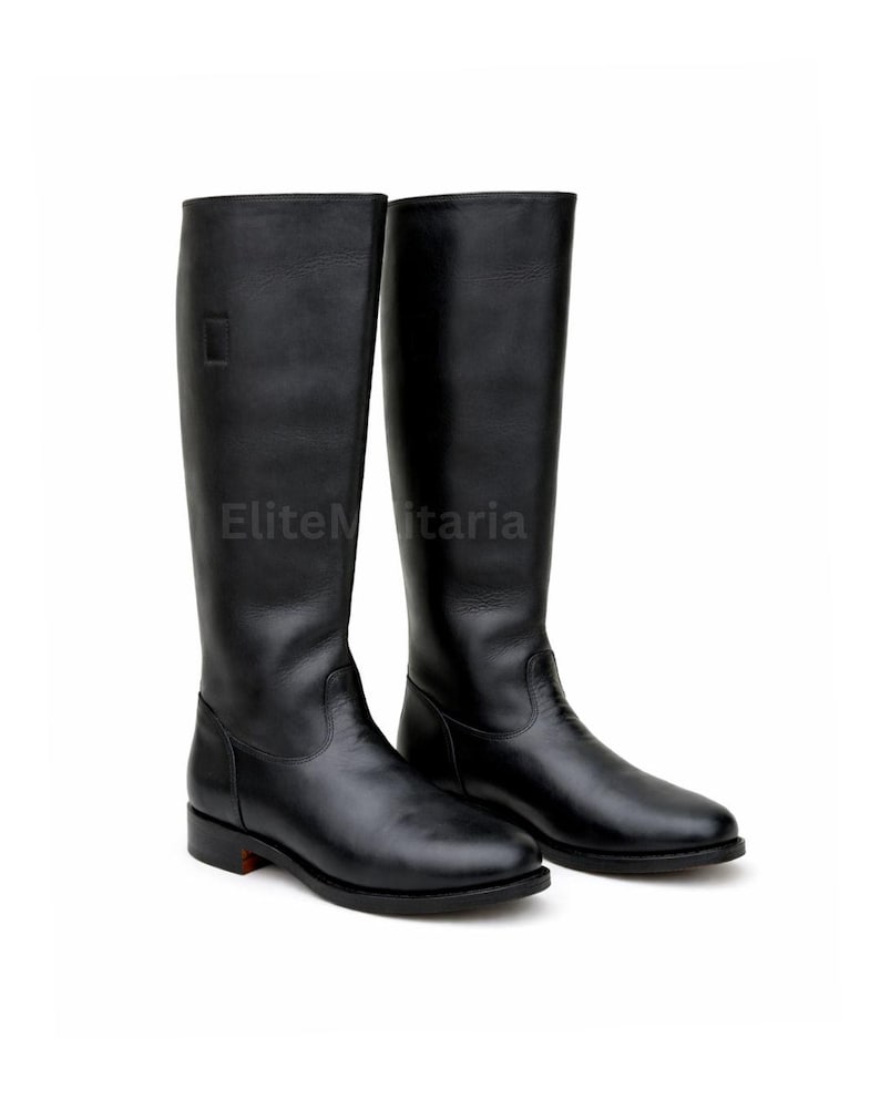 May include: A pair of black leather riding boots. The boots are tall, reaching the mid-calf, with a smooth, polished finish. The boots have a classic design, with a simple, elegant silhouette. The text "EliteMilitaria" is visible on the boots.