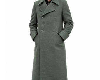 May include: A long, double-breasted wool coat in a muted sage green colour. The coat features wide lapels, two rows of matching green buttons, and long sleeves. It is worn over a black garment, extending down to the mid-calf area with a structured fit.