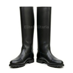 Puede incluir: Un par de botas de montar de cuero negro. Las botas son hasta la rodilla con punta redonda y suela baja con tacos. El texto "Elite Militaria" está impreso en las botas.