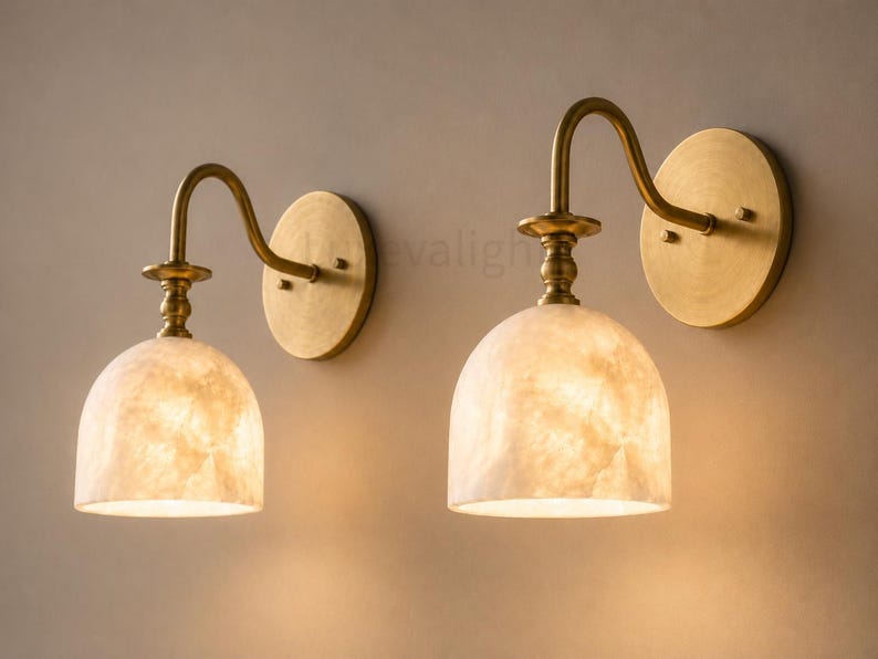 Pair of modern alabaster wall sconces with antique brass finish, handcrafted mid century bathroom vanity wall lights on a warm beige textured wall
Pair of handcrafted alabaster brass wall lights, modern mid century wall sconces for bathroom, bedroom, or entryway
Modern brass wall sconce pair with natural alabaster shades, elegant luxury bathroom vanity lighting fixture
Antique brass alabaster wall light fixture, handmade modern wall sconces with warm illumination for luxury interiors