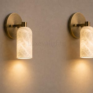 Pair of modern natural alabaster wall sconces in solid antique brass, luxury mid century wall lights for bathroom vanity, bedroom bedside, hallway and living room
Mid century modern solid brass wall sconces with glowing natural alabaster shades for elegant home lighting
Contemporary antique brass wall sconces with natural alabaster cylinder shades, luxury interior wall lighting
Modern alabaster wall sconce pair in solid brass, luxury mid century wall lighting for bedroom and bathroom vanity