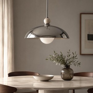 Minimalist chrome dome pendant lamp inspired by vintage Italian modern design, elegant ceiling light for modern home decor
Handmade chrome dome hanging light with warm ambient glow, mid century modern kitchen island lighting fixture
Large polished chrome pendant light with sleek dome shade and alabaster ball accent, luxury modern ceiling fixture
Scandinavian modern chrome dome ceiling light with minimalist hanging rod and soft warm interior lighting aesthetic
Retro futuristic chrome pendant lamp