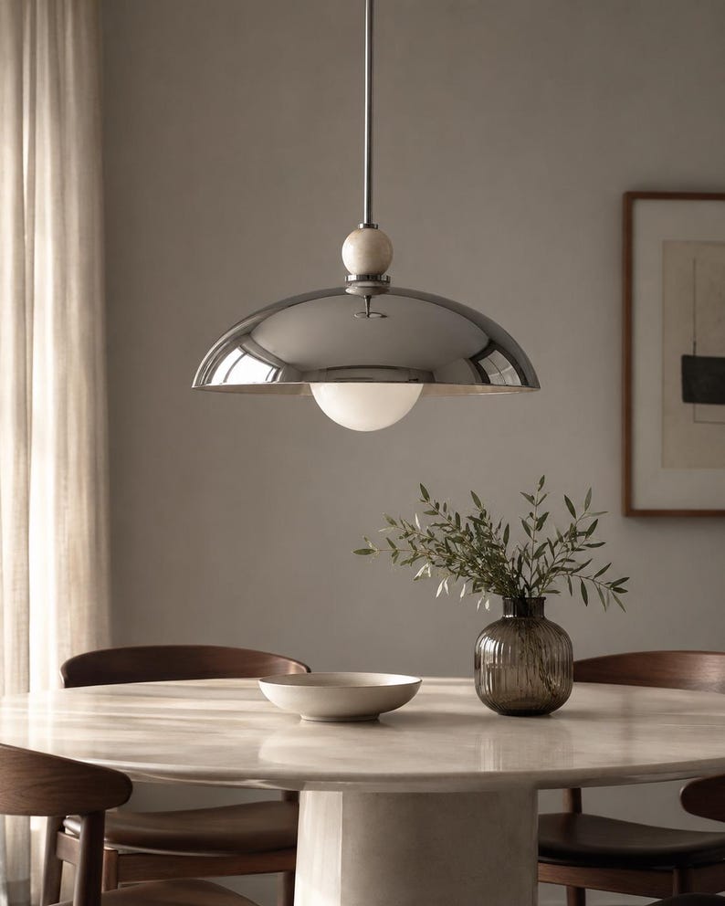 Minimalist chrome dome pendant lamp inspired by vintage Italian modern design, elegant ceiling light for modern home decor
Handmade chrome dome hanging light with warm ambient glow, mid century modern kitchen island lighting fixture
Large polished chrome pendant light with sleek dome shade and alabaster ball accent, luxury modern ceiling fixture
Scandinavian modern chrome dome ceiling light with minimalist hanging rod and soft warm interior lighting aesthetic
Retro futuristic chrome pendant lamp