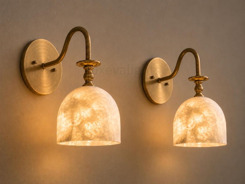 Pair of modern alabaster wall sconces with antique brass finish, handcrafted mid century bathroom vanity wall lights on a warm beige textured wall
Pair of handcrafted alabaster brass wall lights, modern mid century wall sconces for bathroom, bedroom, or entryway
Modern brass wall sconce pair with natural alabaster shades, elegant luxury bathroom vanity lighting fixture
Antique brass alabaster wall light fixture, handmade modern wall sconces with warm illumination for luxury interiors