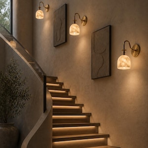 Pair of modern alabaster wall sconces with antique brass finish, handcrafted mid century bathroom vanity wall lights on a warm beige textured wall
Pair of handcrafted alabaster brass wall lights, modern mid century wall sconces for bathroom, bedroom, or entryway
Modern brass wall sconce pair with natural alabaster shades, elegant luxury bathroom vanity lighting fixture
Antique brass alabaster wall light fixture, handmade modern wall sconces with warm illumination for luxury interiors