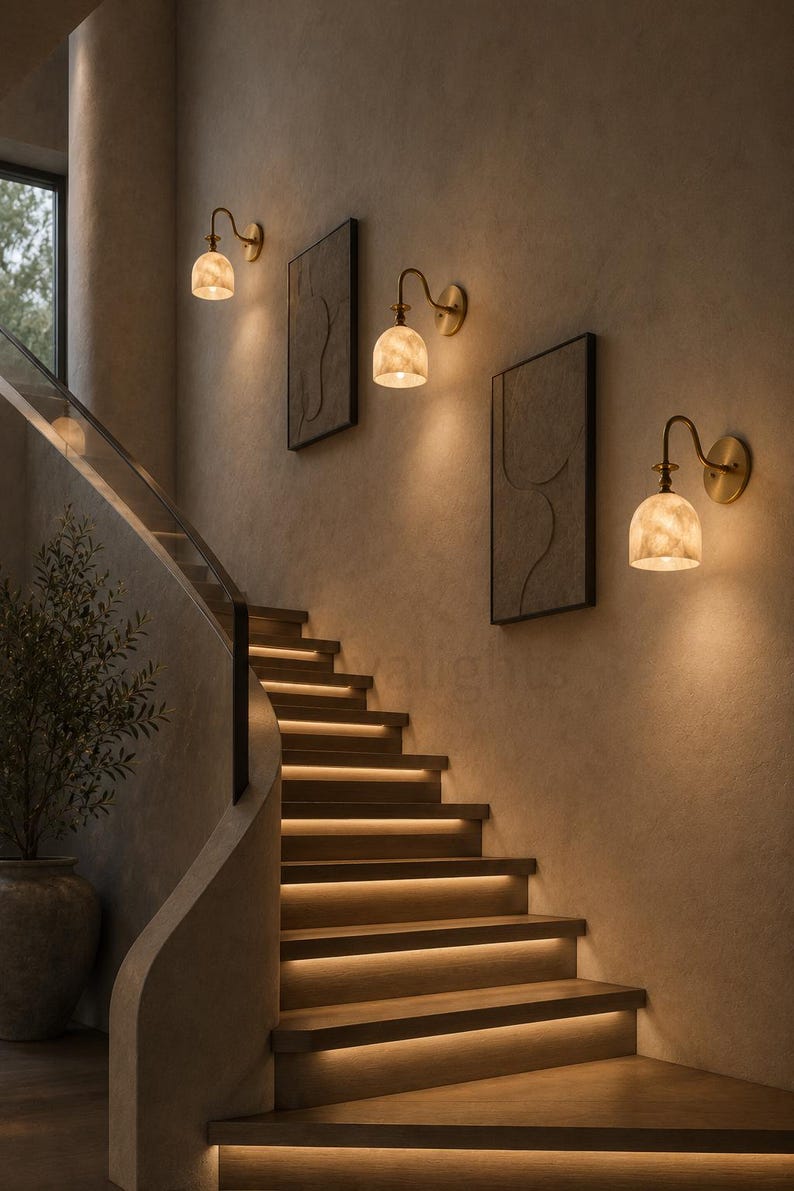 Pair of modern alabaster wall sconces with antique brass finish, handcrafted mid century bathroom vanity wall lights on a warm beige textured wall
Pair of handcrafted alabaster brass wall lights, modern mid century wall sconces for bathroom, bedroom, or entryway
Modern brass wall sconce pair with natural alabaster shades, elegant luxury bathroom vanity lighting fixture
Antique brass alabaster wall light fixture, handmade modern wall sconces with warm illumination for luxury interiors