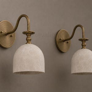 Pair of modern alabaster wall sconces with antique brass finish, handcrafted mid century bathroom vanity wall lights on a warm beige textured wall
Modern alabaster wall sconce pair in antique brass, luxury bathroom vanity wall lights with natural stone shades
Handmade brass alabaster wall sconces, mid century modern bathroom vanity lighting with warm ambient glow
Luxury antique brass wall sconces featuring natural alabaster shades, perfect for bathroom vanity or hallway lighting
brass wall light