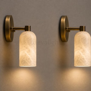 Pair of modern natural alabaster wall sconces in solid antique brass, luxury mid century wall lights for bathroom vanity, bedroom bedside, hallway and living room
Mid century modern solid brass wall sconces with glowing natural alabaster shades for elegant home lighting
Contemporary antique brass wall sconces with natural alabaster cylinder shades, luxury interior wall lighting
Modern alabaster wall sconce pair in solid brass, luxury mid century wall lighting for bedroom and bathroom vanity