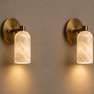 Pair of modern natural alabaster wall sconces in solid antique brass, luxury mid century wall lights for bathroom vanity, bedroom bedside, hallway and living room
Modern antique brass alabaster wall sconce pair with warm lighting for luxury bathroom vanity and bedroom decor
Handmade solid antique brass wall sconces with natural alabaster shades, modern mid century wall lighting
Luxury natural alabaster wall light pair in antique brass finish for bathroom vanity, bedside and hallway lighting