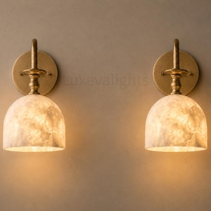 Pair of modern alabaster wall sconces with antique brass finish, handcrafted mid century bathroom vanity wall lights on a warm beige textured wall
Modern alabaster wall sconce pair in antique brass, luxury bathroom vanity wall lights with natural stone shades
Handmade brass alabaster wall sconces, mid century modern bathroom vanity lighting with warm ambient glow
Luxury antique brass wall sconces featuring natural alabaster shades, perfect for bathroom vanity or hallway lighting
brass wall light
