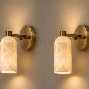 Pair of modern natural alabaster wall sconces in solid antique brass, luxury mid century wall lights for bathroom vanity, bedroom bedside, hallway and living room
Modern antique brass alabaster wall sconce pair with warm lighting for luxury bathroom vanity and bedroom decor
Handmade solid antique brass wall sconces with natural alabaster shades, modern mid century wall lighting
Luxury natural alabaster wall light pair in antique brass finish for bathroom vanity, bedside and hallway lighting