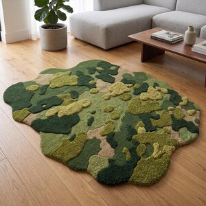 May include: A unique, irregularly shaped rug with a camouflage pattern in shades of green, tan, and olive. The rug is placed on a hardwood floor, adding a touch of nature-inspired design to the room. The rug's texture and color palette create a visually interesting focal point.