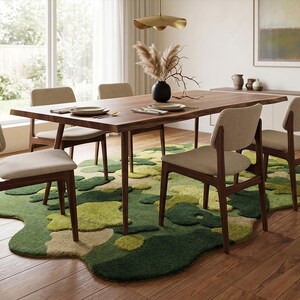 May include: A modern dining room set with a dark wood table, four chairs, and a unique green and beige rug. The table is set with plates and silverware, and a black vase holds decorative branches.