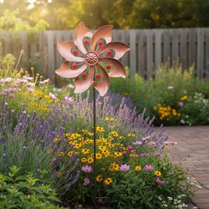 Puede incluir: Una estaca de jardín de metal color cobre con detalles rojos y verdes. La flor tiene ocho pétalos y está montada sobre un poste de metal negro. La estaca está rodeada de una variedad de flores y vegetación coloridas.