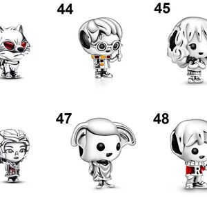May include: A collection of six silver-toned metal charms labeled 43 through 48. The charms feature stylized figures including a fox with red eyes, a boy with glasses and a wand, a girl with curly hair, a figure with wings, an elf, and a boy in a sweater.