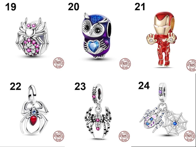 May include: A collection of six sterling silver charms featuring various designs: a spider with pink and clear stones, a purple owl with a blue heart, a red and gold superhero figure, a spider with a red stone, a spider with pink stones, and a spider web charm.